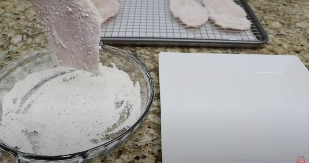 coating the chicken breast with flour